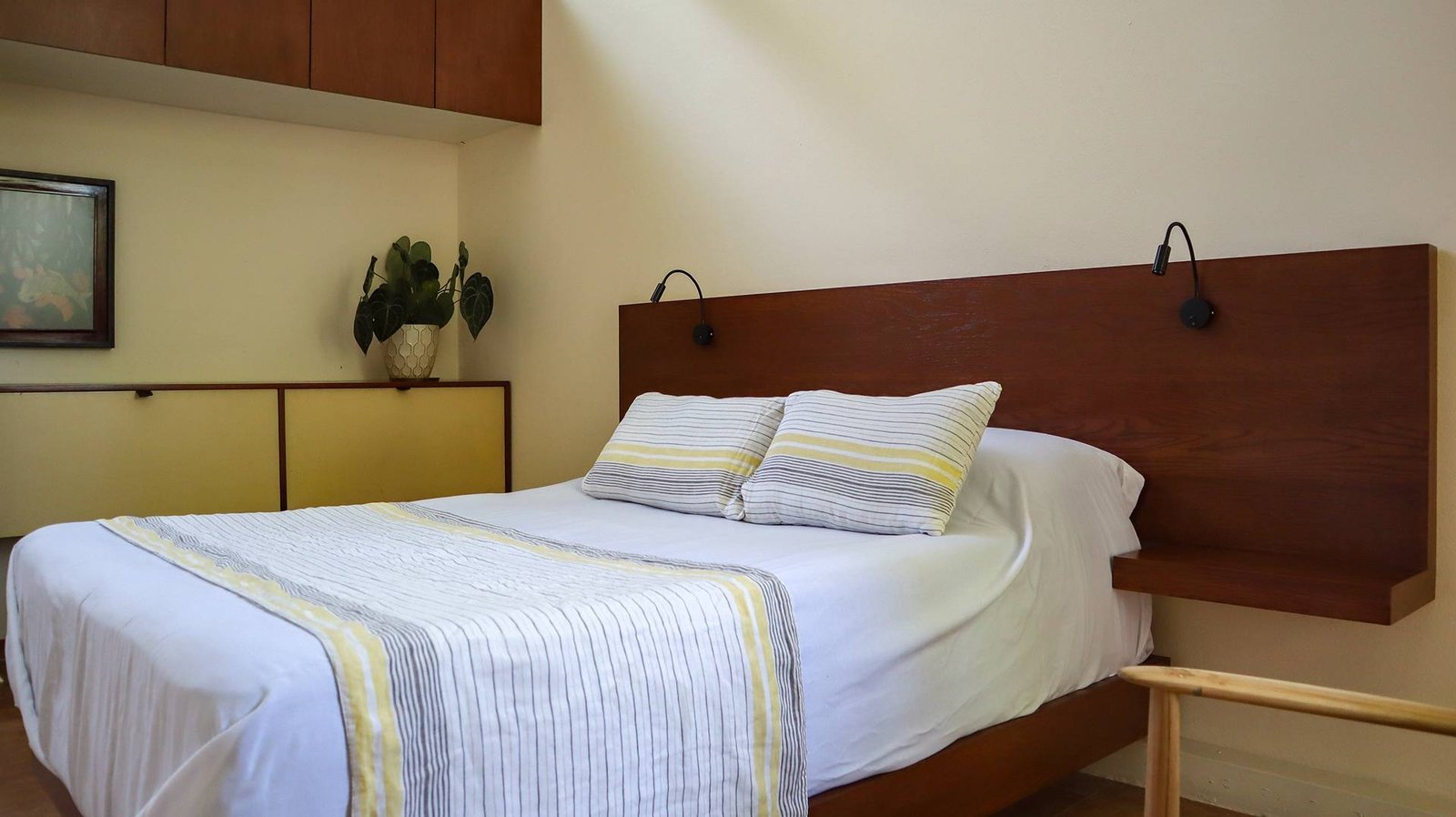 Cama de la recamara con cabecera de madera amplia