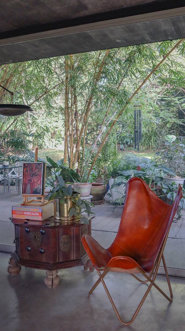 Terraza interior con silla butterfly cuero vista a jardin